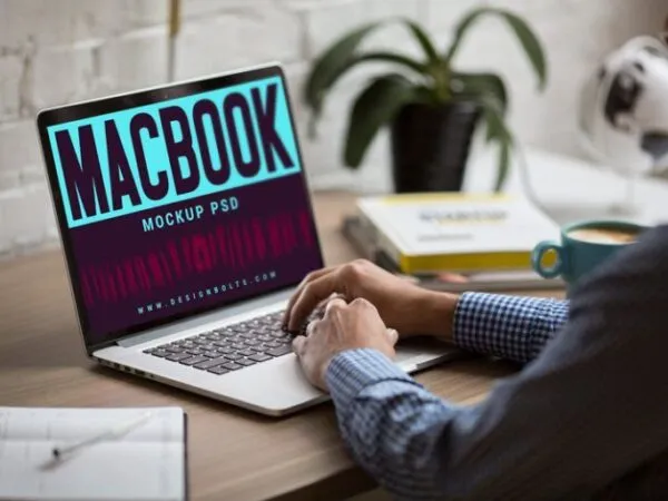 34 View Man Working on MacBook on Office Table Mockup 1