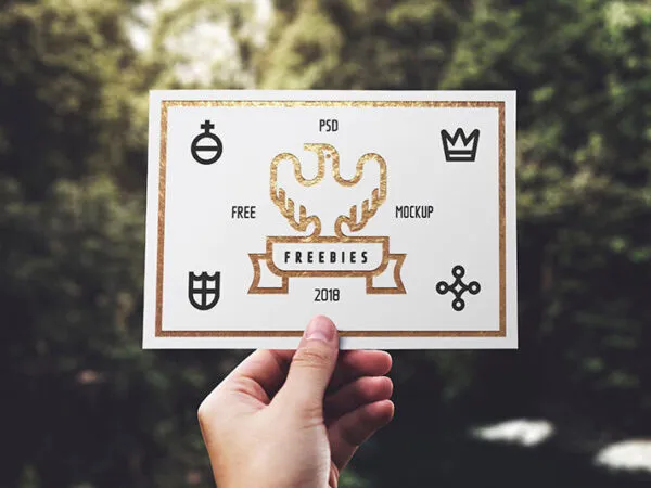A Mans Hand Holding Paper Card Mockup with Nature Background 1