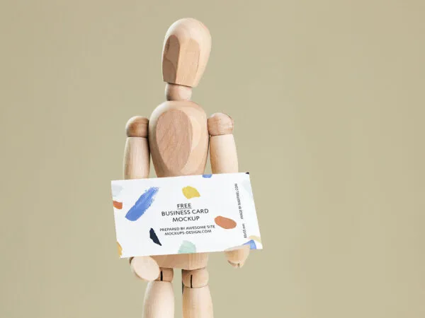 Business Card Held in Hands of a Wooden Manikin Mockup 1