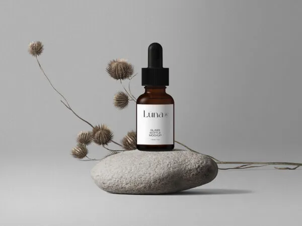 Cosmetic Bottle Mockup with Flower on Stone in Front View 1