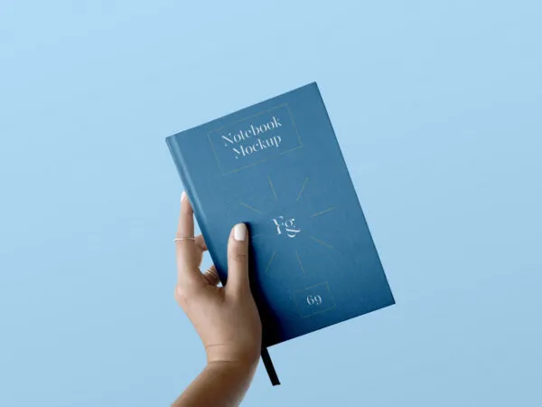 Front View of Hand Holding Notebook Cover Mockup 1
