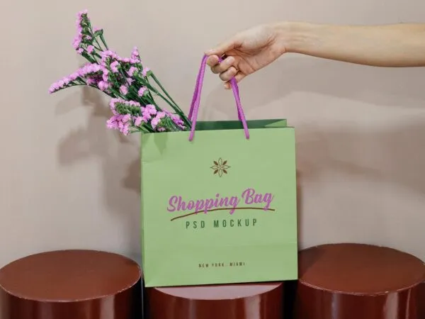 Front View of Hand Holding Paper Shopping Bag Mockup 1
