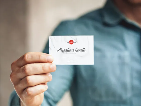 Front View of a Business Card in a Mans Hand Mockup 1