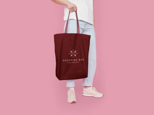 Half Side View Cotton Tote Bag Featuring Someone Holding It Mockup 1