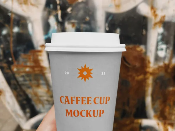 Hand Holding a Coffee Cup on a Street Mockup 1