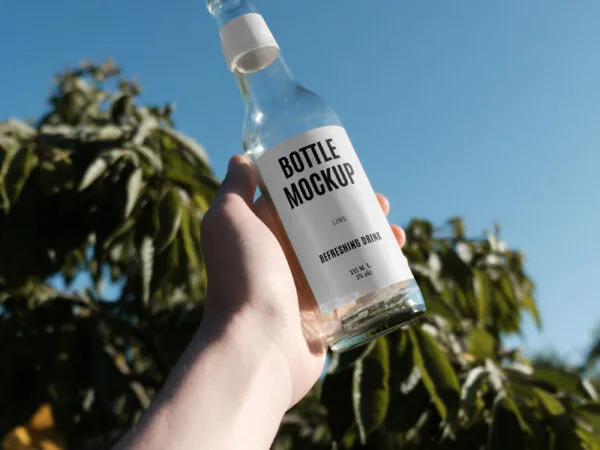 Handholding Glass Bottle Mockup in Nature 1