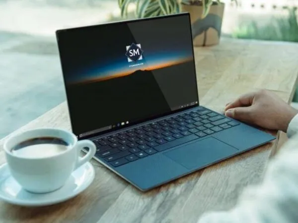 Laptop on a Table in Front of a Man Mockup 1