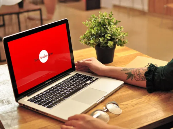 MacBook Pro on Wooden Table in a Cafe Perspective View Mockup 1
