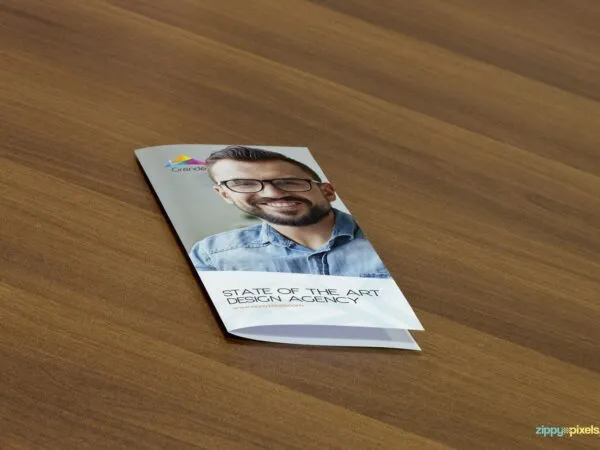 Mockup Displaying a Closed Flyer on a Wooden Table 1