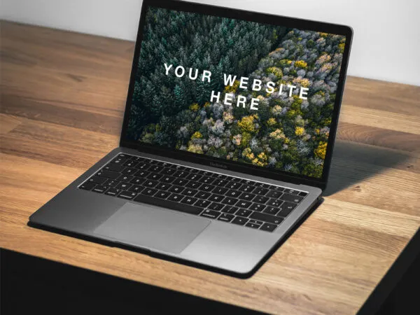 Mockup Featuring 34 View a MacBook Air Facing Light on a Desk 1