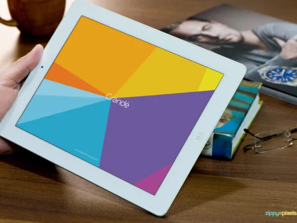 Mockup Featuring Hand Holding iPad on Wooden Table 1
