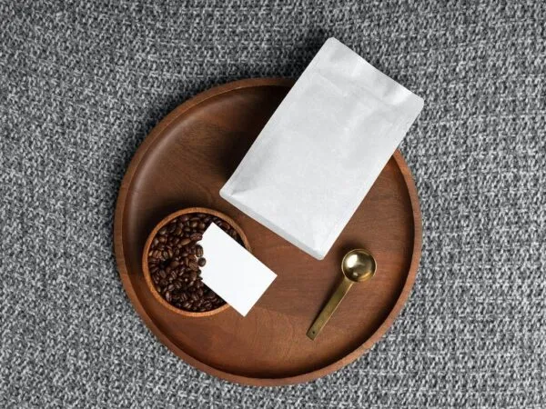 Mockup Featuring Wooden Round Tray Filled with Bowl of Coffee Beans Paper Bag and Business Card 1