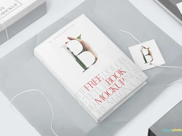Mockup Featuring a Hardcover Book on Wrapping Paper with Tag and Box 1
