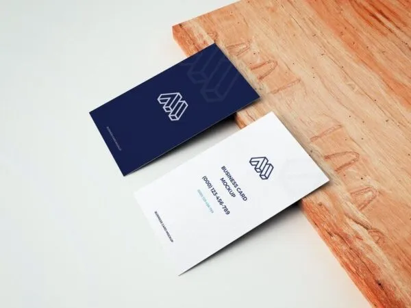 Mockup of Two Business Cards Leaning on Wooden Board in Perspective 1