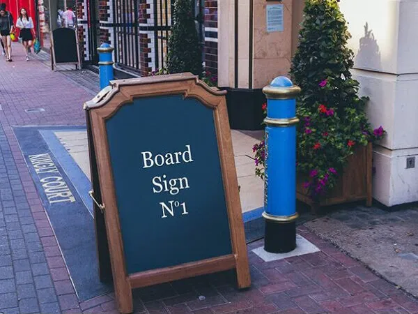 Mockup of a Stylish and Wooden Board Sign on the Street 1