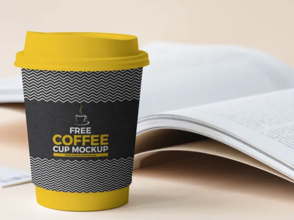 Paper Coffee Cup Standing Next to a Book Mockup 1