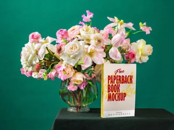 Paperback Book Cover and Spine Mockup on Table with a Glass Vase 1