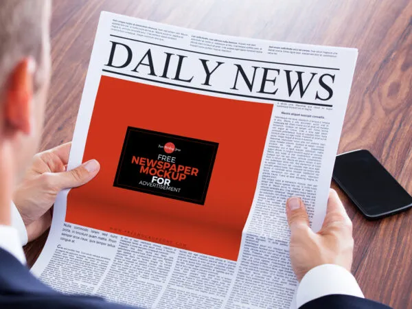 Perspective View of a Newspaper Ad in a Mans Hands Mockup 1