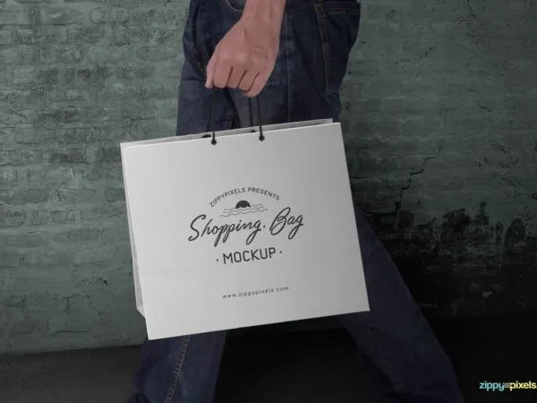 Side View Man Holding a Paper Shopping Bag Mockup 1