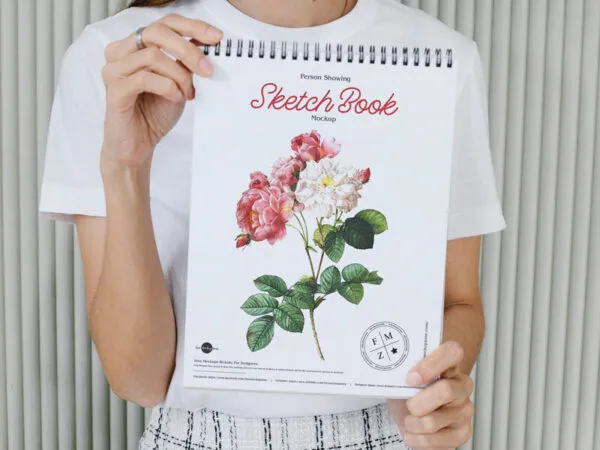 Spiral Bound Sketchbook Mockup Featuring Someone Holding it in Front View 1