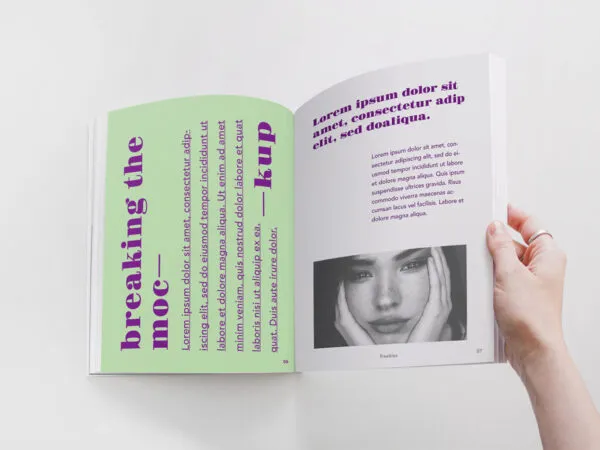 Spread Magazine Held by a Hand Mockup 1