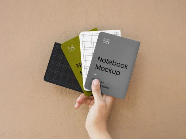 Top View of a Hand Holding Four A5 Notebook Cover Mockup 1