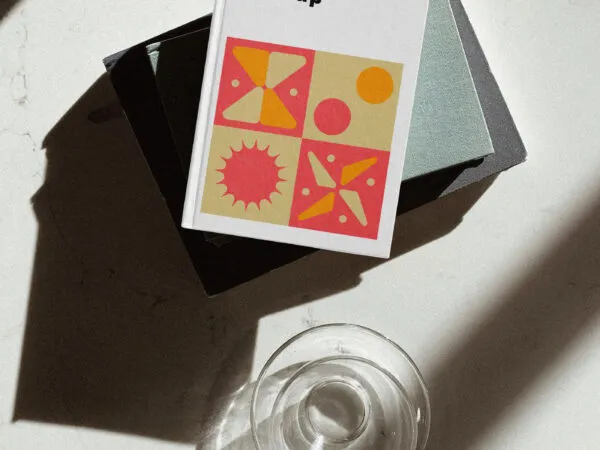 Top View of a Hardcover Book Next to a Glass Mockup 1