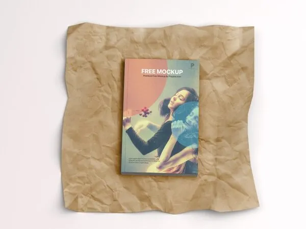 Top View of a Softcover Book on a Wrinkled Paper Mockup 1