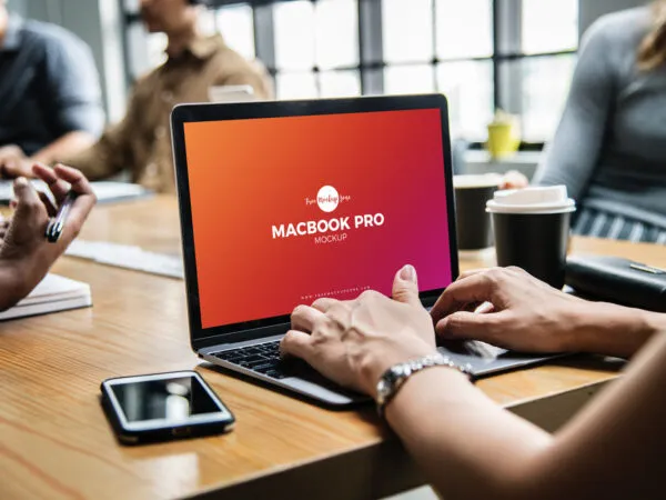 Women Using MacBook Pro on a Wooden Desk Mockup 1