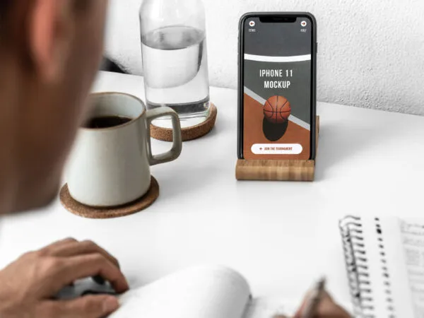 iPhone 11 on a Desk Featuring a Man Mockup 1